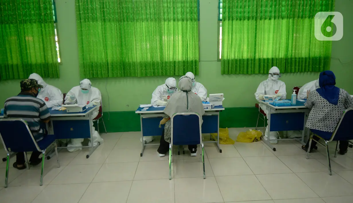 Petugas melakukan pemeriksaan cepat COVID-19 (Rapid Test) kepada tenaga pendidik SMP di SMPN 3 Ciputat, Tangerang Selatan, Kamis (27/08/2020). Rapid tes yang diikuti 400 guru mencakupi wilayah Ciputat dan Ciputat Timur itu untuk mencegah penyebaran Covid-19 di lingkungan pendidikan. (merdeka.com/Dwi