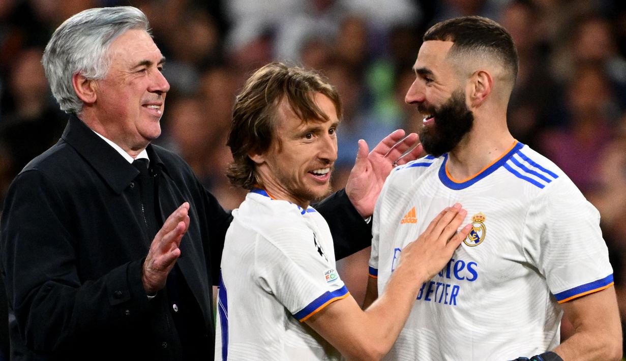 Pemain Real Madrid, Karim Benzema (kanan) merayakan kemenangan atas Manchester City bersama rekan dan pelatihnya, Luka Modric (tengah) dan Carlo Ancelotti pada laga leg kedua semifinal Liga Champions 2021/2022 di Stadion Santiago Bernabeu, Madrid, 4 Mei 2022. (AFP/Gabriel Bouys)