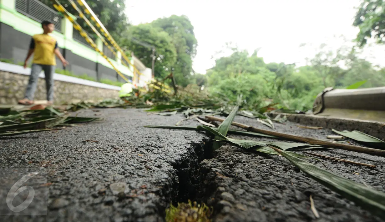 Kondisi sebagian aspal jalan Gardu, Jagakarsa yang mengalami longsor pada Jumat (12/2) lalu, Jakarta, Sabtu (13/2/2016). Longsor terjadi akibat guyuran hujan deras dan tidak ada korban dalam peristiwa ini. (Liputan6.com/Helmi Fithriansyah)