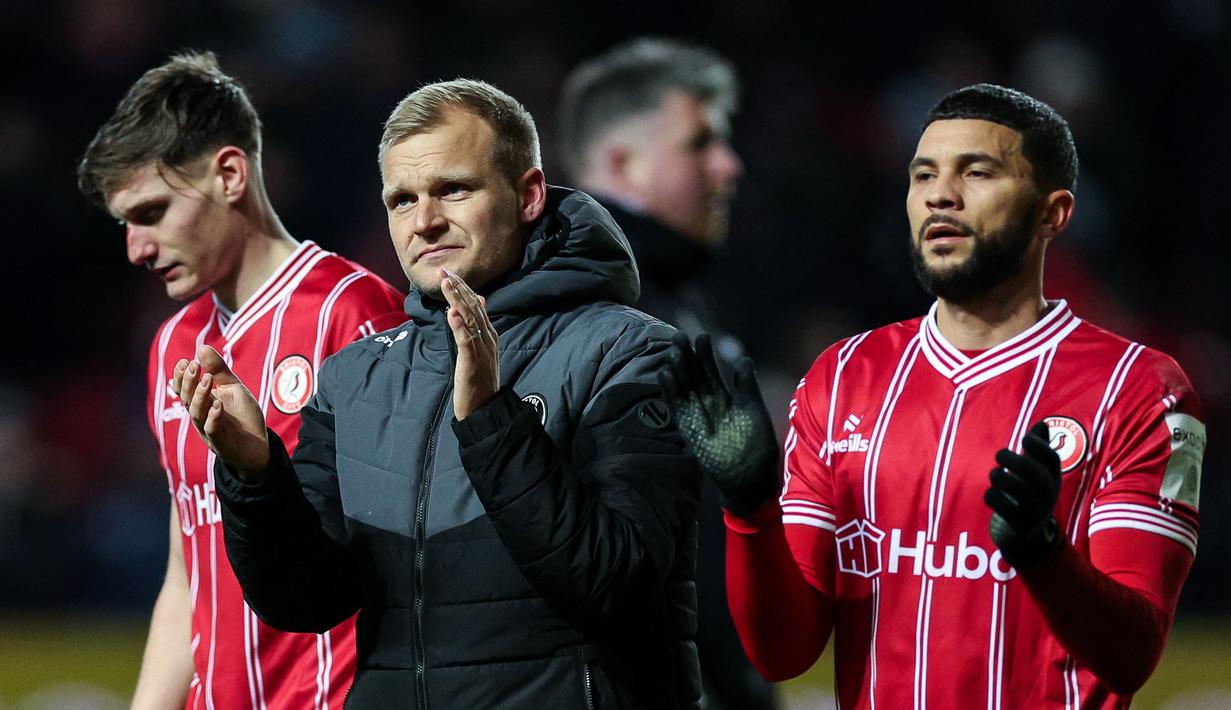 Pealtih kepala Bristol City, Liam Manning (tengah) bersama sejumlah pemain memberikan tepuk tangan di akhir laga putaran ketiga Piala FA 2023/2024 melawan West Ham United di Ashton Gate Stadium, Bristol, Inggris, Rabu (17/01/2024) WIB. (AFP/Adrian Dennis)