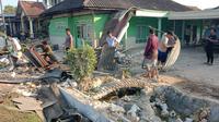 Warga dan polisi gotong royong membersihkan puing-puing rumah yang rusak parah ditabrak mobil bermuatan rokok tak bercukai.