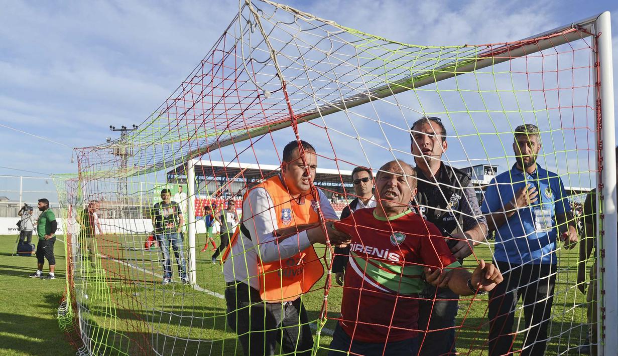 Pihak keamanan menangkap fans klub Amedspor yang kecewa, Selasa (16/5/2017) di play-off untuk Liga Super Turki. (AFP/Ilyas Akengin)