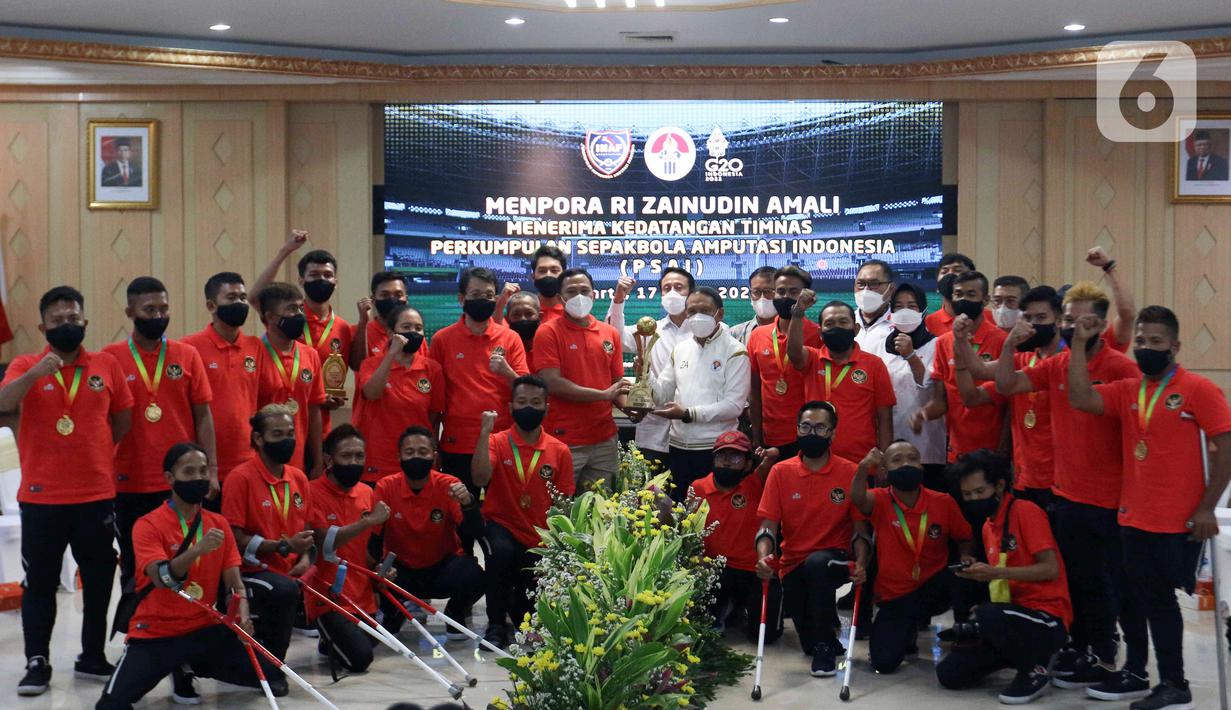 Menpora Zainudin Amali (tengah kanan) berfoto bersama pemain Timnas Sepak Bola Amputasi Indonesia di Gedung Kemenpora, Jakarta, Kamis (17/3/2022). Menpora menyatakan pemerintah berkomitmen untuk mendukung kemajuan Timnas Sepak Bola Amputasi Indonesia. (Liputan6.com/Herman Zakharia)