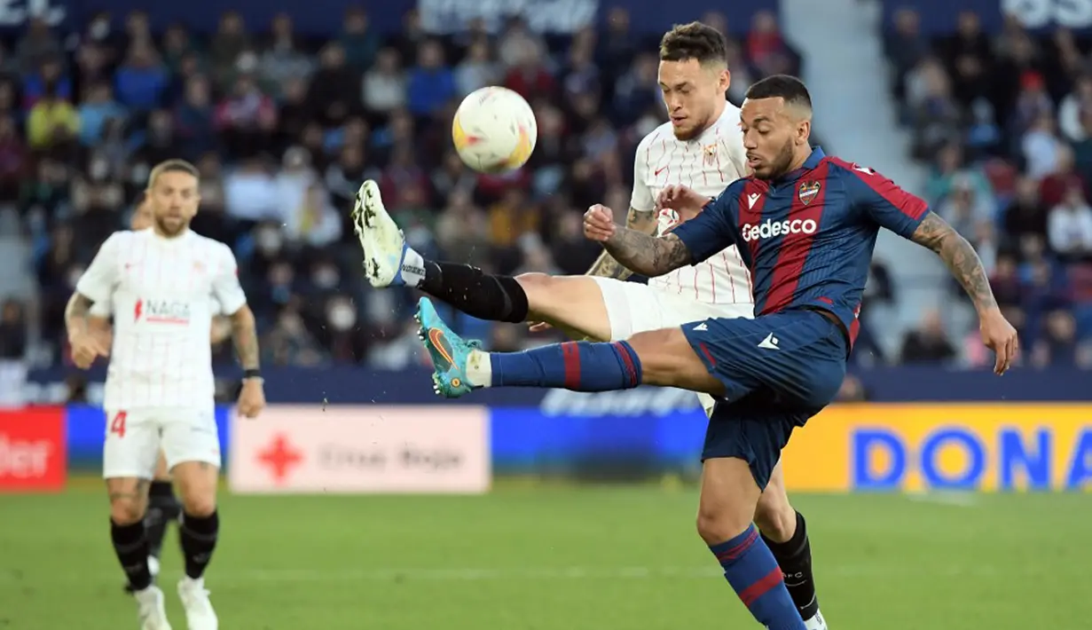 <p>Pemain Levante Ruben Vezo (kanan) berebut bola dengan pemain Sevilla Lucas Ocampos pada pertandingan Liga Spanyol di Stadion Ciutat de Valencia, Valencia, Spanyol, 21 April 2022. Sevilla menang 3-2. (Jose Jordan/AFP)</p>