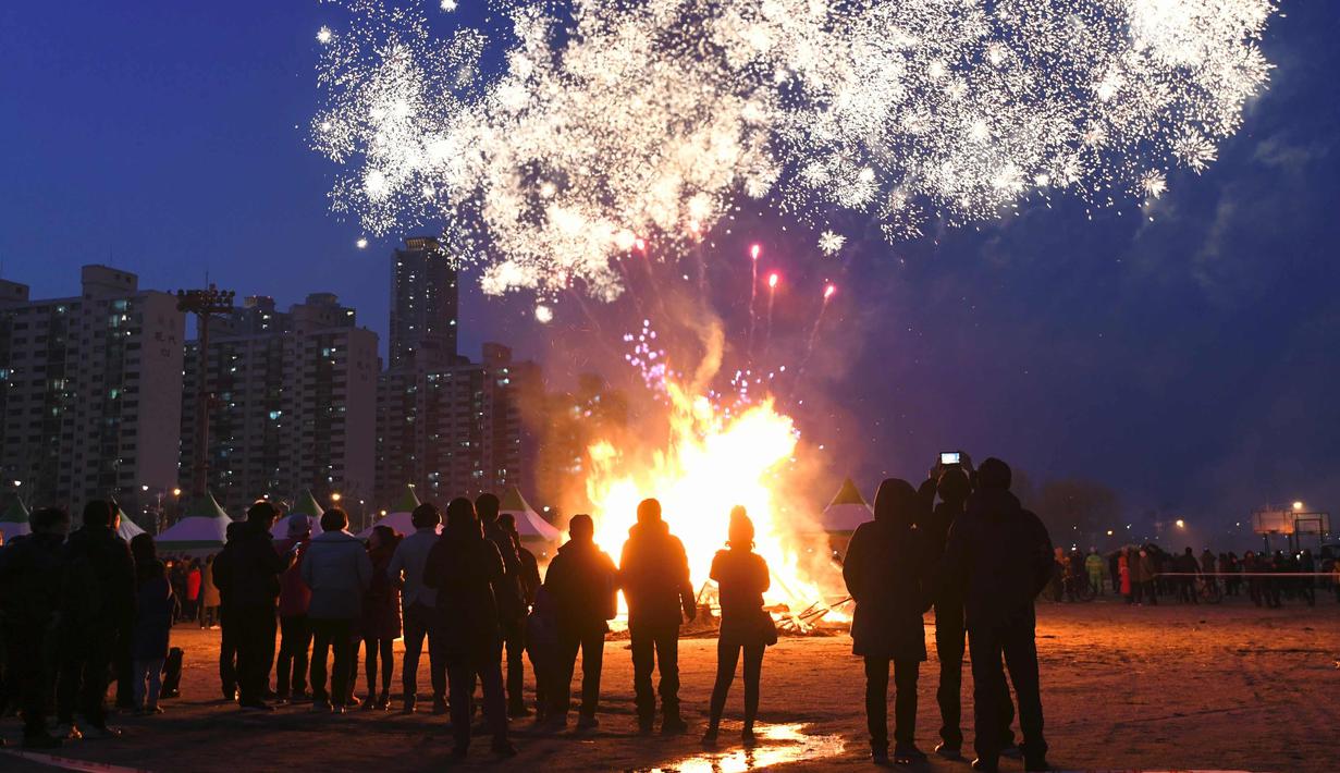 Peserta menyaksikan kembang api menjelang perayaan "Jeongwol Daeboreum" di Seoul, Korea Selatan (1/3). Jeongwol Daeboreum merupakan perayaan hari libur tradisional Korea untuk merayakan bulan purnama pertama kalender lunar. (AFP Photo/Jung Yeon-je)