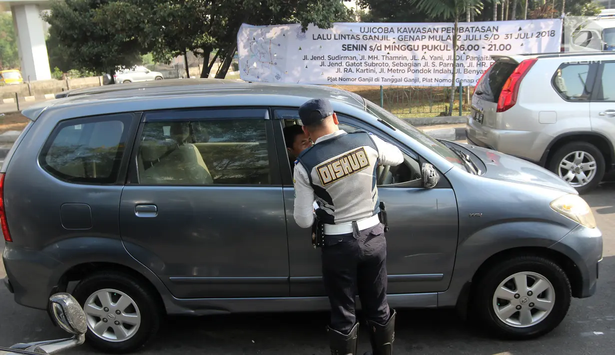 Petugas Dishub DKI membagikan selebaran untuk mensosialisasikan perluasan ganjil genap di kawasan Tomang, Jakarta, Senin (2/7). Hari ini merupakan hari pertama uji coba yang digelar jelang pelaksanaan Asian Games 2018. (Liputan6.com/Arya Manggala)