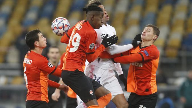 Pemain Shakhtar Donetsk, Manor Solomon dan Valeriy Bondar berebut bola dengan penyerang Real Madrid, Mariano Diaz pada matchday kelima Grup B Liga Champions di NSK Olimpiyskiy, Kiev, Rabu (2/12/2020) dini hari WIB. Real Madrid tumbang 0-2 di markas Shakhtar Donetsk. (AP Photo/Efrem Lukatsky)