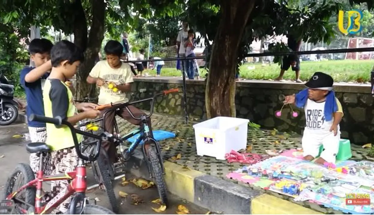 Mengaku tengah sepi job, berbagai usaha pun dilakukan Ucok Baba untuk menghasilkan pundi-pundi. Kini, semangatnya beralih ke jualan lato-lato. Di mana permainan tersebut memang sedang viral di masyarakat. Tidak terduga, rupanya dagangan sang artis ramai diserbu oleh anak-anak yang penasaran dengan permainan tersebut. (Liputan6.com/YouTube/@UcokBabaofficial)