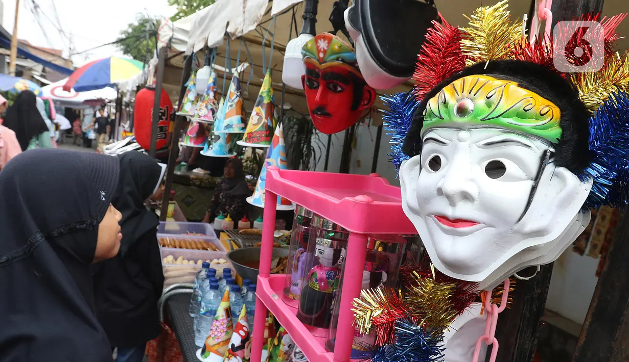 Sejumlah anak melihat topeng saat mengunjungi Festival Tugu Pancoran di Jakarta, Minggu (1/12/2019). Festival Tugu Pancoran yang digelar setiap setahun sekali ini indetik dengan budaya betawi. (Liputan6.com/Herman Zakharia)
