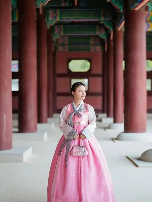 Rossa tampil menawan dalam balutan hanbok bernuansa merah muda yang cerah. Tak hanya itu, ia bahkan membawa tas tangan yang serasi dan menata rambutnya dengan gaya digulung ke belakang. [Foto: Instagram/itsrossa910]