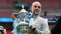Manajer Manchester City, Pep Guardiola, berpose dengan trofi di lapangan setelah pertandingan final Piala FA Inggris antara Chelsea melawan Manchester City di Stadion Wembley, London, pada 16 Mei 2026. City memenangkan pertandingan dengan skor 1-0. Gelar FA Cup ketiga pada era kepelatihan Guardiola tersebut mengakhiri rentetan dua kekalahan beruntun City di partai final. (Adrian Dennis / AFP)