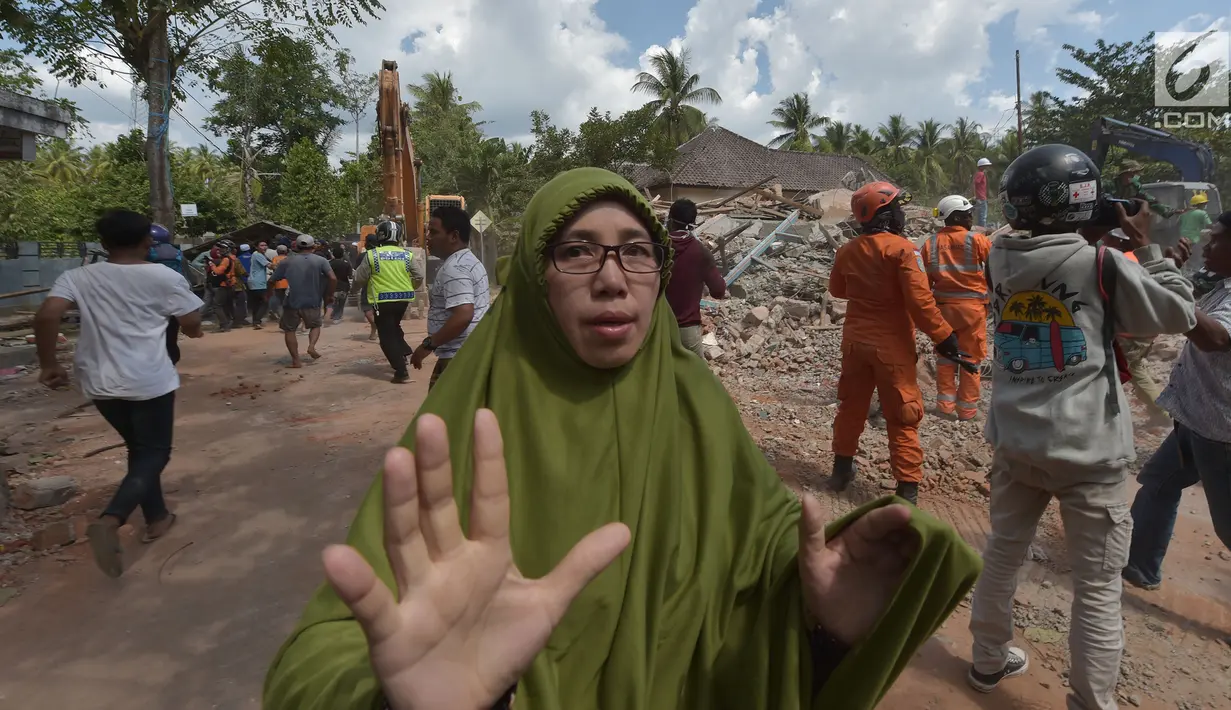 Seorang wanita berlari mencari tempat perlindungan saat terjadi gempa susulan di Tanjung pulau Lombok, NTB, Kamis (9/8). Menurut BNPB pusat gempa berada di enam kilometer barat laut Lombok Utara dengan kedalaman 12 kilometer. (AFP/ ADEK BERRY)