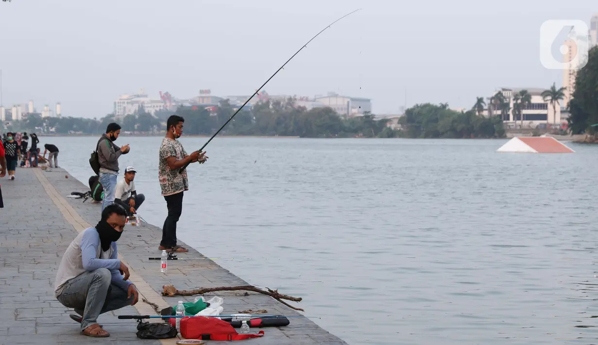 Warga memancing di area pedestrian Danau Sunter, Jakarta, Sabtu (27/6/2020). Beragam aktivitas dilakukan warga sambil menikmati waktu sore di area Danau Sunter, Jakarta. (Liputan6.com/Helmi Fithriansyah)