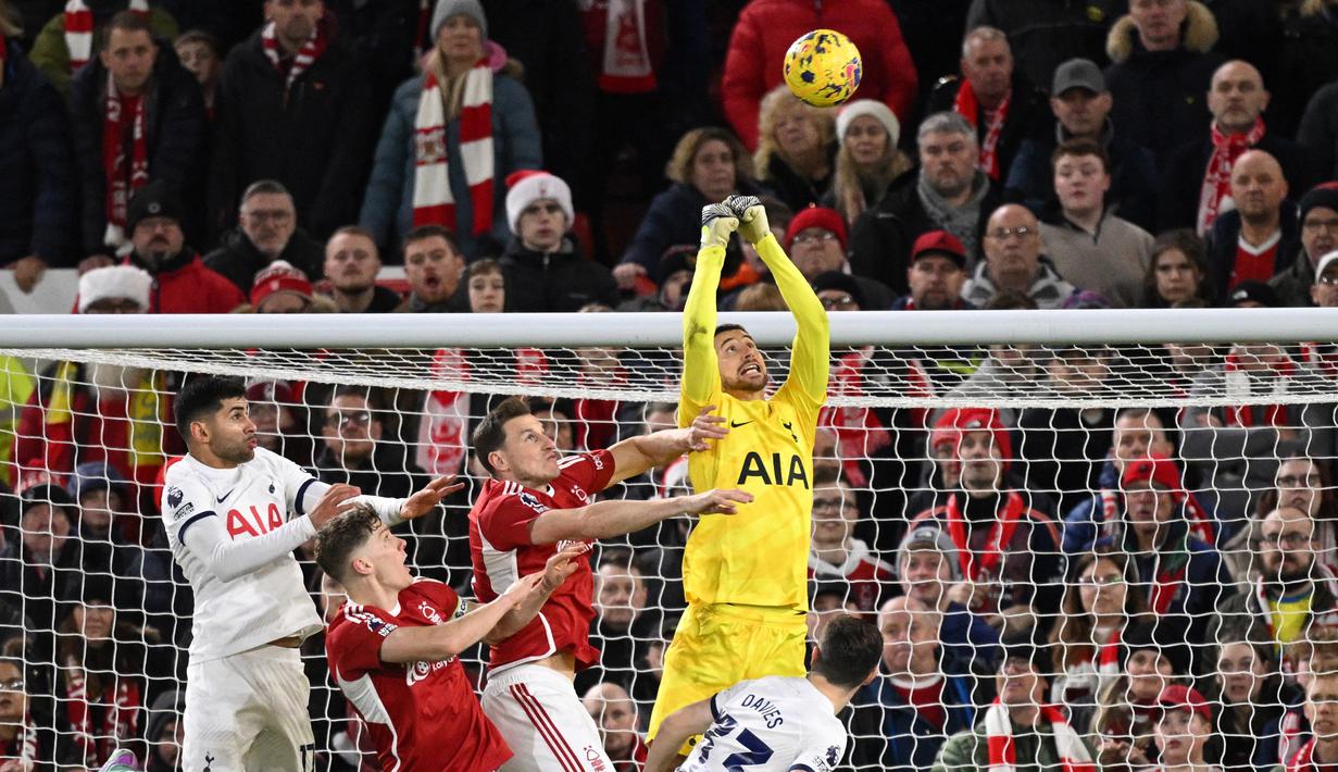Kiper Tottenham Hotspur asal Italia, Guglielmo Vicario (kanan), berhasil menghalau bola tendangan sudut dari pemain Nottingham Forest dalam pertandingan pekan ke-17 Liga Inggris 2023/2024 yang berlangsung di The City Ground, Sabtu (16/12/2023) dini hari WIB. (AFP/Oli Scarff)
