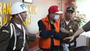 Buronan koruptor Atto Sakmiwata Sampetoding (tengah) digiring petugas di Gedung Kejaksaan Agung, Jakarta, Kamis (21/11/2019). Tim Kejagung bersama Ditjen Imigrasi dan KBRI Kuala Lumpur memulangkan buronan koruptor Rp 24 miliar yang telah divonis 5 tahun penjara. (Liputan6.com/Helmi Fithriansyah)