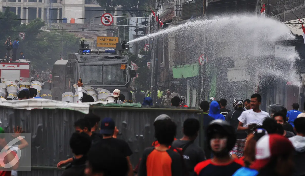 Petugas membubarkan massa dengan mengunakan water canon saat penggusuran Kampung Pulo, Jakarta, Kamis (20/8/2015). Penggusuran pemukiman Kampung Pulo dilakukan oleh 2.200 personel gabungan untuk normalisasi Sungai Ciliwung. (Liputan6.com/Herman Zakharia)