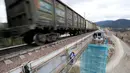 Kereta barang melintas saat pekerja menyelesaikan proyek jembatan kereta api tertinggi di Rusia, yang berada di Taiga, daerah timur Pegunungan Sayan Ridge dekat stasiun kereta Dzheb di Krasnoyarsk, Rusia (10/11). (REUTERS/Ilya Naymushin)