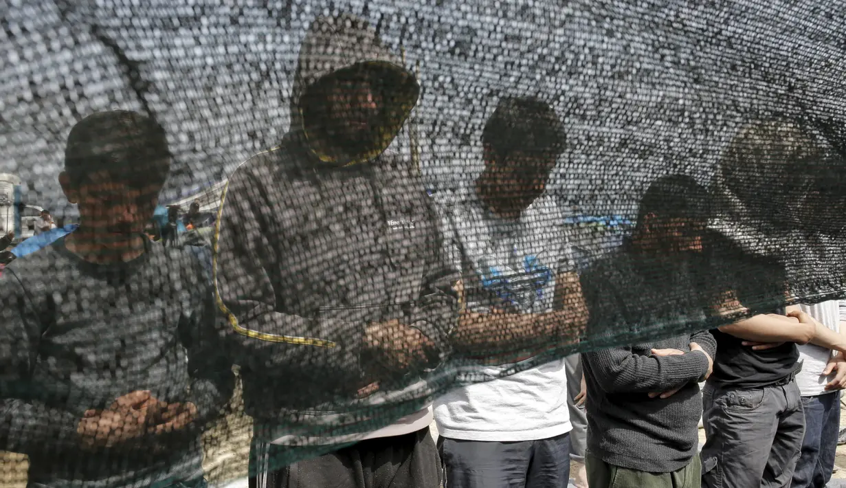 Para imigran tampak khusyuk saat menggelar salat Jumat di sebuah kamp darurat perbatasan Yunani-Makedonia,desa Idomeni, Yunani (8/4). Meski tengah mencari perlindungan, mereka tak melalaikan kewajibannya sebagai seorang muslim. (REUTERS/Marko Djurica)