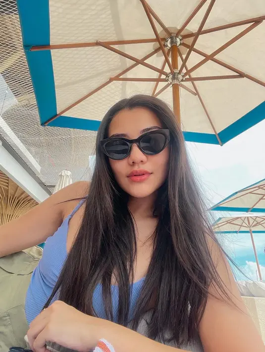 Menikmati waktu santainya, Aaliyah yang cantik mengenakan tanktop biru ini semakin elegan dengan kacamata hitam serta rambut panjangnya yang terurai. (Liputan6.com/IG/@aaliyah.massaid)