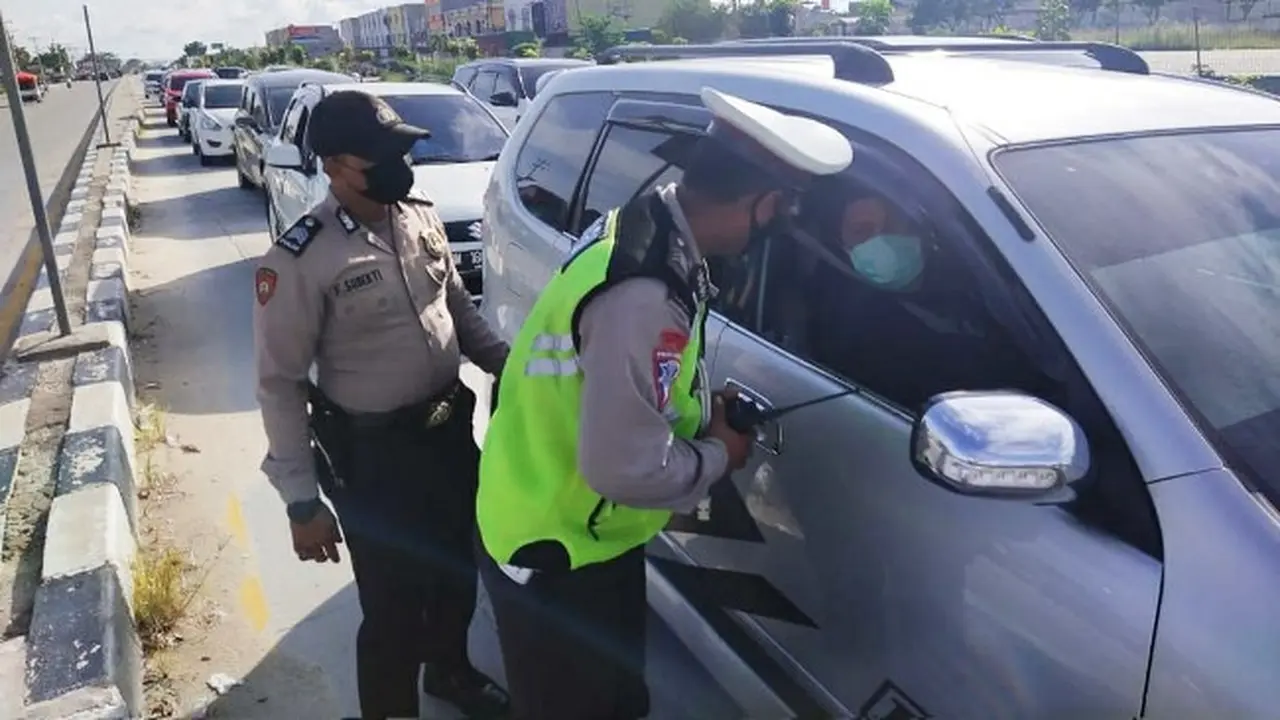 Personel Polresta Pekanbaru memeriksa kendaraan di pos penyekatan larangan mudik.