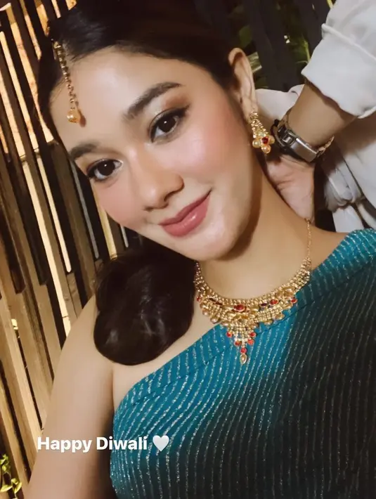 Naysilla Mirdad tampil dengan aksesori khas perempuan India, dari hiasan kepala, anting, hingga kalungnya. Ia pun mengenakan busana warna kehijauan. [@naymirdad]