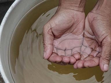 Warga menunjukkan air tanah di kawasan Muara Angke, Jakarta, Sabtu (26/2/2022). Sejak tahun 1980-an, warga Muara Angke, Jakarta Utara, mengalami kesulitan mendapatkan air bersih. (Liputan6.com/Faizal Fanani)