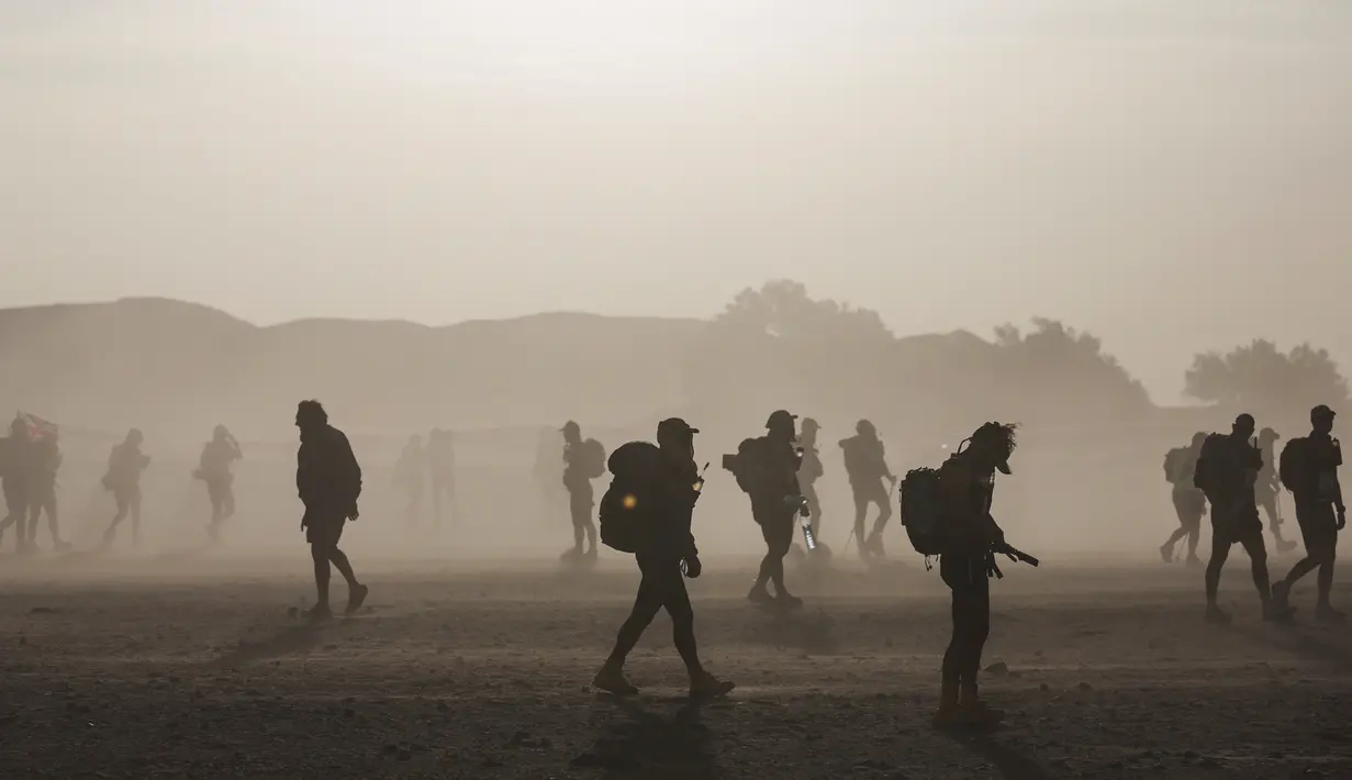Sejumlah peserta berjalan saat terjadi badai pasir dalam kompetisi Marathon des Sables ke-33 di gurun Sahara, Maroko (13/4). Sekitar 1.000 peserta dari 50 negara ikut berkompetisi dalam Marathon des Sables ini. (AP Photo / Mosa'ab Elshamy)
