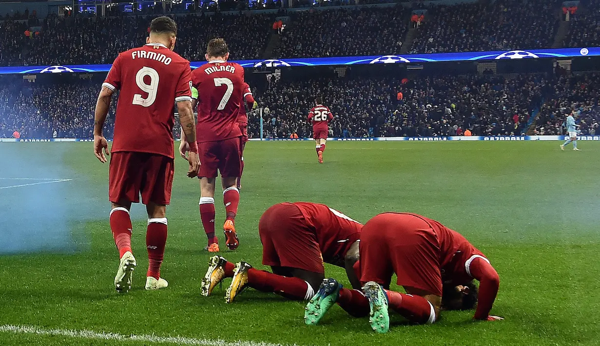Pemain Liverpool Mohamed Salah (kanan) bersama rekannya Sadio Mane melakukan sujud syukur saat melakukan selebrasi usai mencetak gol ke gawang Manchester City di Etihad Stadium (10/4). Pada pertandingan itu Liverpool menang 2-1. (AFP/Paul Ellis)