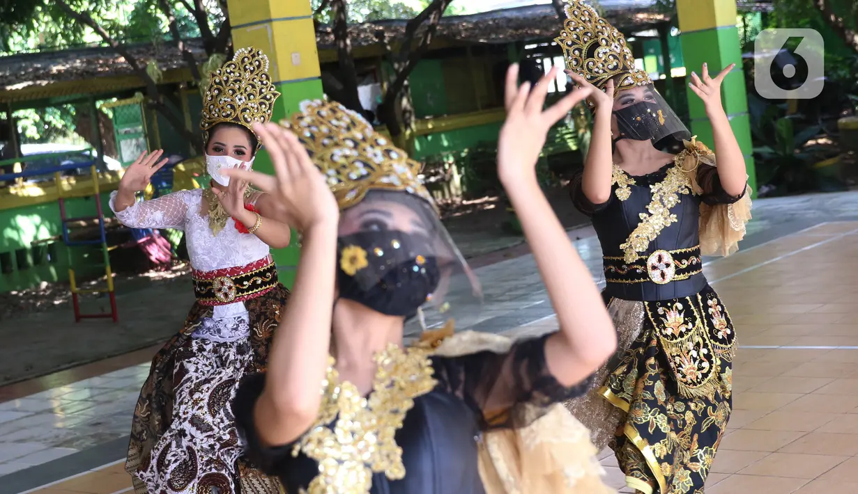 Penari tradisional dari Sanggar Eschoda melakukan latihan menggunakan masker dan pelindung wajah di Kota Tangerang, Jumat (12/6/2020). Para penari itu menerapkan protokol kesehatan jelang new normal atau tatanan hidup normal, sekaligus sebagai upaya pencegahan Covid-19. (Liputan6.com/Angga Yuniar)