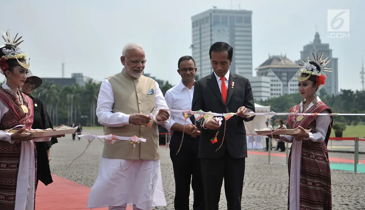 Presiden Joko Widodo (Jokowi) dan PM India Narendra Modi memotong pita saat meresmikan pameran Indonesia-India Kite  Exhibition di kawasan Monas, Jakarta, Rabu (30/5). Pada pameran tersebut, dipamerkan puluhan layang-layang. (Merdeka.com/Iqbal S. Nugroho)