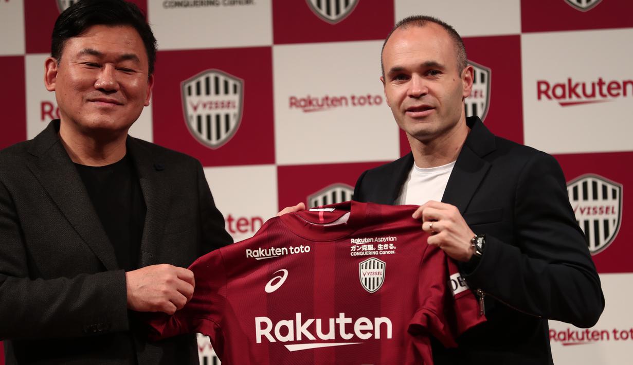Mantan pemain Barcelona, Andres Iniesta (kanan) memegangn jersey bersama Presiden klub Vissel Kobe, Hiroshi Mikitani di Tokyo, (24/5/2018). Andres memilih bergabung dengan Vissel Kobe selama tiga musim. (AFP/Behrouz Mehri)