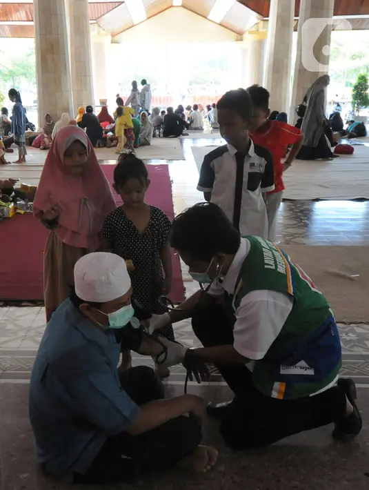 Paramedis memeriksa kesehatan pengungsi korban ledakan kilang minyak Balongan di Pendopo Kabupaten Indramayu, Senin (29/03/2021). Sekitar 900 warga saat ini mengungsi dari lima desa terdampak ledakan kilang minyak Balongan.  (merdeka.com/Arie Basuki)