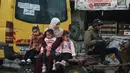 Selain itu, banyak dari sekolah-sekolah yang masih digunakan sebagai tempat penampungan bagi pengungsi. Tampak dalam foto, seorang wanita mengantar anak-anaknya ke sekolah dengan kereta kuda di Deir al-Balah, di Jalur Gaza tengah, pada 10 Desember 2025. (BASHAR TALEB/AFP)
