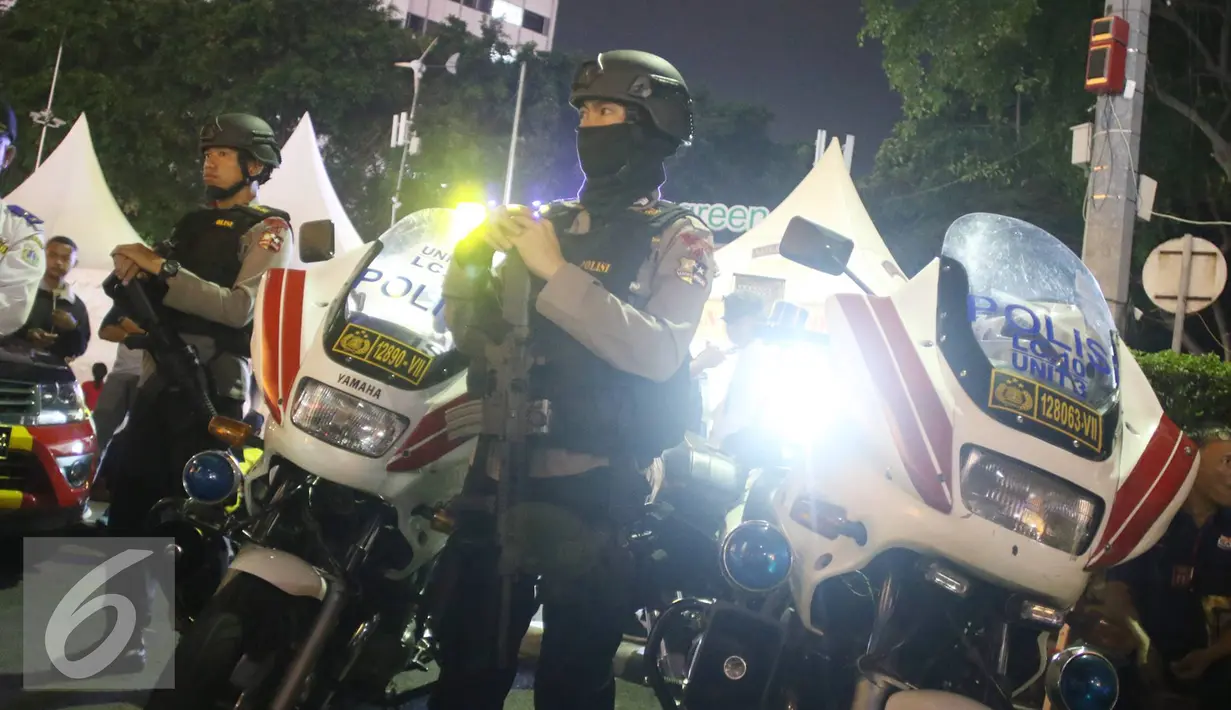 Sejumlah petugas kepolisian berjaga di kawasan Bundaran HI, Jakarta, Sabtu (31/12). Sebelumnya, Pempro DKI Jakarta akan mengadakan car free night di sepanjang Jalan Sudirman hingga MH Thamrin pada malam pergantian tahun. (Liputan6.com/Immanuel Antonius)