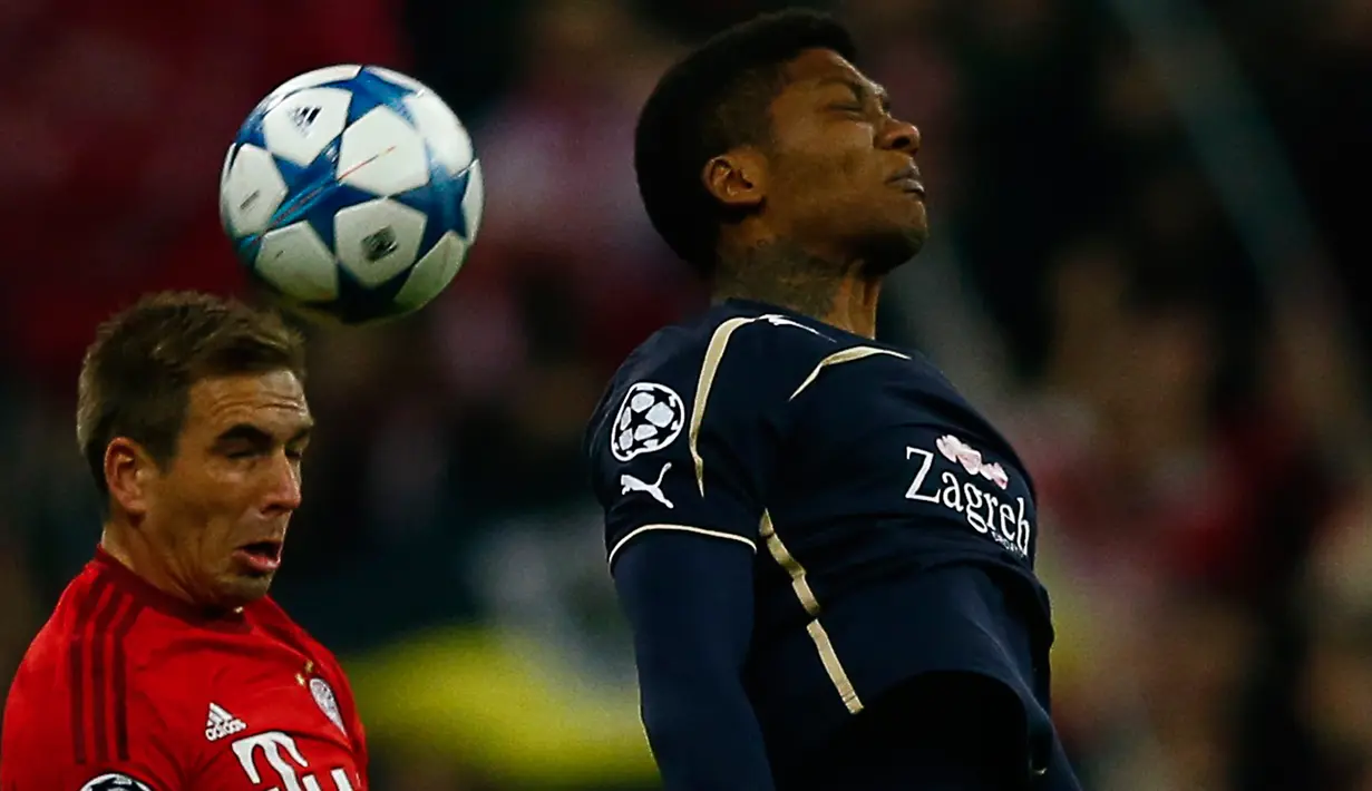Bek Muenchen, Philipp Lahm (kiri) berebut bola udara dengan Gelandang Dinamo Zagreb, Junior Fernandes pada laga Liga Champions di Allianz Arena, Jerman (30/9/2015). Muenchen menang telak atas Dinamo Zegreb dengan skor 5-0. (REUTERS/Michael Dalder)