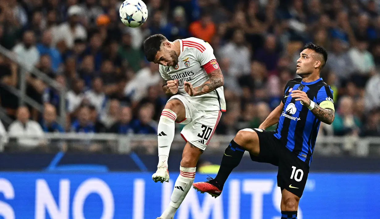 Bek Benfica #30 Nicolas Otamendi menyundul bola di depan penyerang Inter Milan #10 Lautaro Martinez pada matchday 2 Liga Champions 2023/2024 di Giuseppe Meazza, Italia, Rabu (4/102/2023) WIB. (GABRIEL BOUYS / AFP)