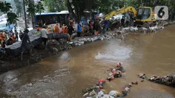 Petugas gabungan saat penanganan tanggul Kalibaru yang jebol di Simpang Hek, Kramatjati, Jakarta Timur, Senin (25/3/2024). (merdeka.com/Imam Buhori)