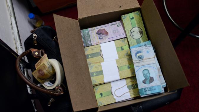 Sejumlah uang lokal ditumpuk didalam kardus di Caracas, Venezuela (15/12). Mata uang lokal yang bernama Panal ini diluncurkan di lingkungan kelas pekerja 