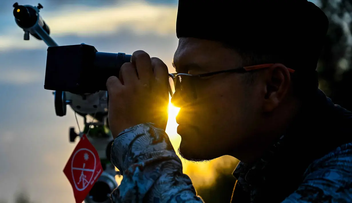 Seorang petugas observatorium mengamati bulan, menjelang Idul Fitri sekaligus menandai berakhirnya bulan suci Ramadan1447 Hijriah melalui teleskop di kantor observatorium, pantai Lhoknga, Aceh pada Kamis 19 Maret 2026. Salah satu metode dalam menentukan awal bulan Hijriah, umat Islam menggunakan rukyat hilal. (CHAIDEER MAHYUDDIN/AFP)