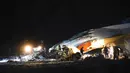 Pekerja darurat bekerja di samping pesawat Antonov An-26 yang jatuh di Bandara Almaty, Kazakhstan, Sabtu (13/3/2021). Antonov An-26 merupakan pesawat transportasi militer buatan Rusia. (AP Photo/Vladimir Tretyakov)