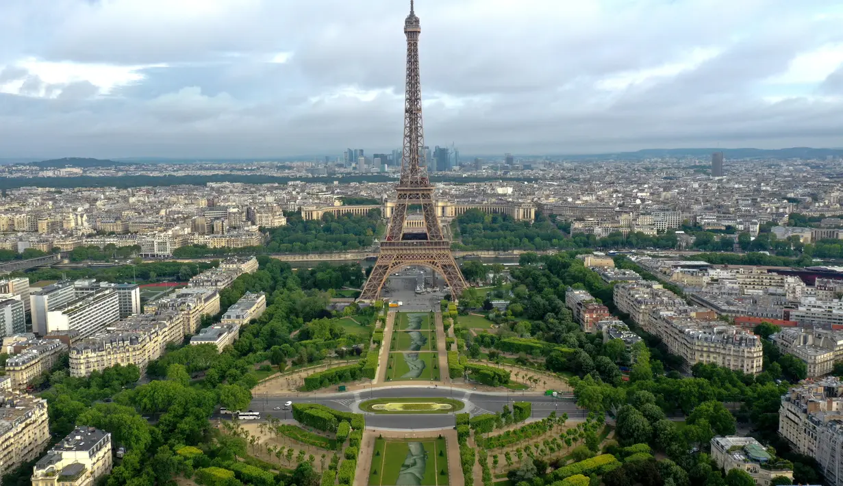 Foto udara dari lukisan raksasa "Beyond Walls" karya seniman jalanan Prancis, Saype, yang terbentang di halaman Champs de Mars, depan Menara Eiffel di Paris, 13 Juni 2019. Karya berukuran 600 meter itu bentuk dukungan kepada organisasi amal penyelamat migran, SOS Mediterranee. (Eric FEFERBERG/AFP)