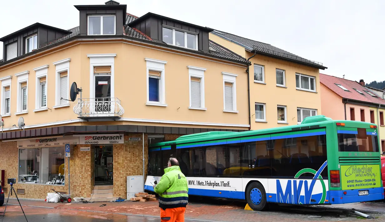 Bus sekolah terparkir di depan bangunan setelah menabrak tembok sebuah toko di Eberbach dekat Mannheim, Jerman, Selasa (16/1). Setidaknya 48 orang terluka dalam kecelakaan bus yang membawa anak-anak sekolah tersebut. (Uwe Anspach/dpa via AP)