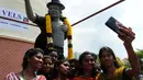 Sejumlah pelajar mengambil foto bersama patung bintang pop AS Michael Jackson di Chennai, India, Kamis (7/4).Patung tersebut juga dikalungi oleh Varmala khas India. (Arun Sankar/AFP)