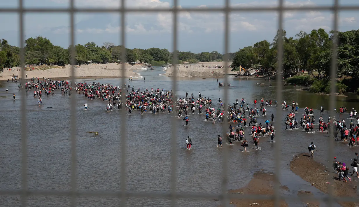 Migran Amerika Tengah menyeberangi Sungai Suchiate dengan berjalan kaki dari Guatemala ke Meksiko, Tecun Uman, Guatemala, Senin (20/1/2020). Lebih dari seribu migran Amerika Tengah yang terdampar di Guatemala berjalan massal untuk menuju Amerika Serikat. (AP Photo/Moises Castillo)