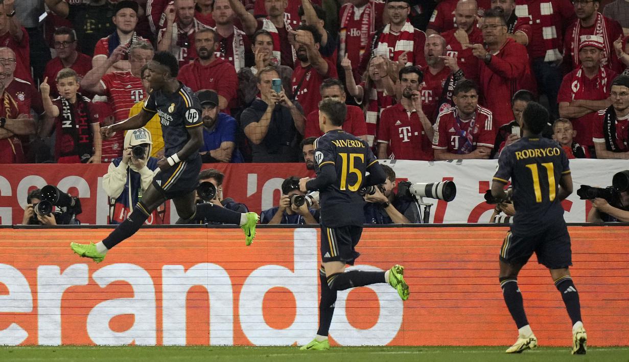 Selebrasi striker Real Madrid, Vinicius Junior (kiri) setelah mencetak gol penyeimbang 2-2 ke gawang Bayern Munchen melalui eksekusi penalti pada laga leg pertama semifinal Liga Champions 2023/2024 di Allianz Arena, Munich, Selasa (30/4/2024). (AP Photo/Matthias Schrader)