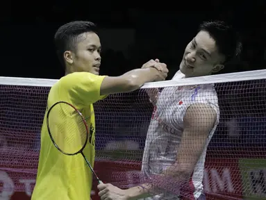 Tunggal putra Indonesia, Anthony Sinisuka Ginting, bersalaman dengan wakil Jepang, Kento Momota, pada Indonesia Open di Istora Senayan, Kamis, (5/7/2018). Anthony Ginting takluk 14-21, 15-21. (Bola.com/M Iqbal Ichsan)