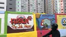 Pengendara motor mengamati mural bertema Kota Jakarta di sekitar Rusunawa KS Tubun, Jakarta, Senin (23/11/2020). Mural tersebut dibuat guna memercantik lingkungan di sekitar rusun agar lebih berwarna dan tidak tampak kumuh. (Liputan6.com/Immanuel Antonius)
