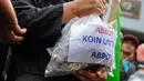Massa Pro-Indonesia menunjukan ribuan koin untuk PM Tony Abbot di depan Gedung Kedubes Australia, Jakarta, Selasa (10/3/2015). Koin tersebut bentuk protes atas pernyataan PM Australia Tony Abbott. (Liputan6.com/Faizal Fanani) 