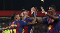 Pemain Barcelona, Raphinha (kiri), merayakan gol yang dicetaknya ke gawang Valencia pada pekan 4 Liga Spanyol 2025/2026, Senin (15/9/2025) dini hari WIB. (Lluis GENE / AFP)