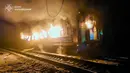 Presiden Ukraina, Volodymyr Zelensky mengecam serangan Rusia terhadap sebuah kereta penumpang sebagai terorisme. Tampak foto yang dirilis oleh Layanan Darurat Ukraina pada 27 Januari 2026 ini menunjukkan gerbong kereta yang terbakar setelah serangan udara di lokasi yang tidak diungkapkan di wilayah Kharkiv, di tengah invasi Rusia ke Ukraina. (Handout/UKRAINIAN EMERGENCY SERVICE/AFP)